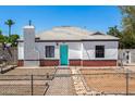 Charming home with red brick accents, white paint, gray roof and turquoise front door at 2802 E Virginia Ave, Phoenix, AZ 85008