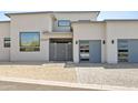 A modern home showcasing an elegant entryway and attractive garage doors at 28349 N 113Th St, Scottsdale, AZ 85262