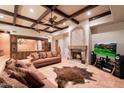 Cozy living room featuring tile flooring, ceiling fans, a fireplace, coffered ceilings, and comfortable seating at 31721 N 138Th Pl, Scottsdale, AZ 85262