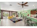 Bright open-concept living room features a ceiling fan and large windows overlooking the backyard at 41227 N Rolling Green Way, Anthem, AZ 85086