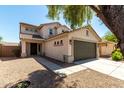 Charming two-story home featuring a two-car garage, desert landscaping, and a covered front porch at 41251 W Cahill Dr, Maricopa, AZ 85138