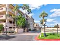 Beautiful condo building with lush landscaping and palm trees in a well-maintained community at 4200 N Miller Rd # 408, Scottsdale, AZ 85251