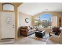 Inviting living room with large windows, vaulted ceiling, and comfortable seating at 42076 W Colby Dr, Maricopa, AZ 85138