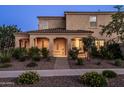 Exterior evening shot of a cozy two-story home with a welcoming entrance and thoughtfully designed front yard landscaping at 5016 S Curie Way, Mesa, AZ 85212