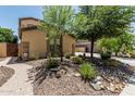 Landscaped front yard featuring desert plants, trees, and a paved walkway leading to the entrance of the home at 5437 W Red Bird Rd, Phoenix, AZ 85083