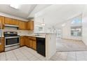 Bright kitchen with a view of the living room featuring wooden cabinets and stainless steel appliances at 6719 W Sack Dr, Glendale, AZ 85308