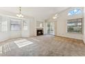 Cozy living room with a fireplace, a ceiling fan, and natural light streaming through the window at 6719 W Sack Dr, Glendale, AZ 85308