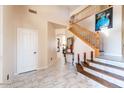 Bright foyer with tile flooring, a staircase, and a neutral color palette at 7102 W Pueblo Ave, Phoenix, AZ 85043