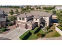 A well-manicured two-story home with a three-car garage, desert landscaping, and lawn at 7102 W Pueblo Ave, Phoenix, AZ 85043