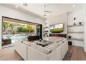 Modern living room with a fireplace, TV, and sliding glass doors to the outdoor pool area at 7710 E Tardes Dr, Scottsdale, AZ 85255
