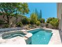 Inviting backyard pool and spa with well-manicured landscaping and lush greenery at 7710 E Tardes Dr, Scottsdale, AZ 85255