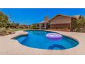 Inviting backyard featuring a private pool, lush lawn, and serene patio area perfect for relaxation and entertaining at 8803 N 105Th Dr, Peoria, AZ 85345