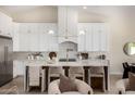 Bright kitchen featuring white cabinets, a large center island with seating, and modern pendant lighting at 9112 E Palm Tree Dr, Scottsdale, AZ 85255