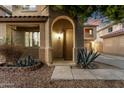 Inviting front entrance with covered porch, arched entryway, and desert landscaping at 9350 W Williams St, Tolleson, AZ 85353