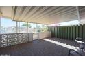 Covered patio featuring brick pavers, decorative block walls, and wrought iron gate access to backyard at 10307 W Oakmont Dr, Sun City, AZ 85351