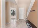 Inviting home foyer featuring hard surface floors, a staircase, and a bench at 11836 W Planada Ct, Sun City, AZ 85373