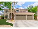 Charming two-story home boasts lush landscaping, a three-car garage, and a welcoming entrance with a beautiful tiled roof at 1571 E Saratoga Ct, Gilbert, AZ 85296