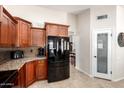 Efficient kitchen featuring dark wood cabinetry, granite countertops, and black appliances, offering style and functionality at 1630 W Calle Del Norte --, Chandler, AZ 85224