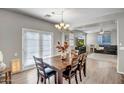 Bright dining room with a wooden table, seating for six, and double doors to the outside at 17802 N 114Th Ln, Surprise, AZ 85378
