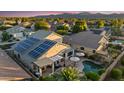 Aerial view of the backyard with a pool, patio, and solar panels on the roof at 18030 W Caribbean Ln, Surprise, AZ 85388