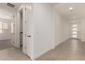 Bright hallway showcasing tile flooring, a laundry room, and access to other areas of the house at 19434 S 212Th Pl, Queen Creek, AZ 85142