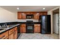 Kitchen with black appliances, oak cabinets and tile floors at 19601 N 7Th St # 1003, Phoenix, AZ 85024