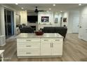 Open living room with hardwood floors, comfortable seating, a ceiling fan, fireplace and access to backyard at 19882 N Crimson Ridge Way, Surprise, AZ 85374