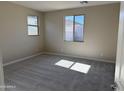 Bedroom with neutral paint, a large window providing natural light, and plush carpeting at 23214 W Miami St, Buckeye, AZ 85326