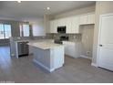 Modern kitchen features stainless steel appliances, a central island, and sleek white cabinets at 23214 W Miami St, Buckeye, AZ 85326