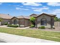 Charming single-story home featuring stone accents, a tile roof, and manicured landscaping at 2370 W Maplewood St, Chandler, AZ 85286
