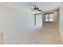 Spacious bedroom with neutral carpet, a ceiling fan, and a sliding glass door to the patio at 23853 W Hammond Ln, Buckeye, AZ 85326
