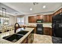 Stylish kitchen featuring granite counters, dark cabinets, and modern appliances at 31133 N 132Nd Ln, Peoria, AZ 85383