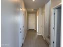 Inviting hallway features neutral colored walls, wood-style tile flooring, and access to various rooms at 3125 S 232Nd Ave, Buckeye, AZ 85326