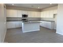 Modern kitchen featuring white cabinetry, stainless steel appliances, and a center island with granite countertops at 3125 S 232Nd Ave, Buckeye, AZ 85326