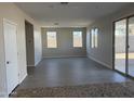 Spacious living room with gray tile flooring, neutral paint, and a sliding glass door at 3125 S 232Nd Ave, Buckeye, AZ 85326