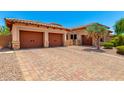 Beautiful home featuring stone accents, desert landscaping, a two-car garage and brick driveway at 4041 N Silver Ridge Cir, Mesa, AZ 85207