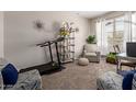Versatile bonus room featuring neutral walls, a treadmill, and comfortable seating, flooded with natural light at 4108 N 304Th Ln, Buckeye, AZ 85396