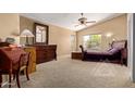 Cozy bedroom with carpeted floors, a ceiling fan, and a bright, sunny window at 4514 E Verbena Dr, Phoenix, AZ 85044