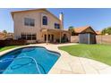 Inviting backyard oasis featuring a sparkling pool, lush lawn, and covered patio at 4514 E Verbena Dr, Phoenix, AZ 85044