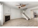 Bright living room with a fireplace, ceiling fan, wood floors, and a staircase at 4901 E Kelton Ln # 1251, Scottsdale, AZ 85254
