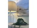 Intimate view of home decor with a muted desert landscape painting hanging above a lamp and a small potted plant at 7261 E Norland St, Mesa, AZ 85207
