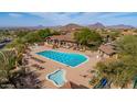 Aerial view of community pool with mature landscaping and desert mountain views in the distance at 7261 E Norland St, Mesa, AZ 85207