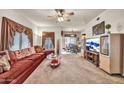 Spacious living room with ceiling fan and view into adjacent dining area at 7401 W Arrowhead Club Dr # 2067, Glendale, AZ 85308