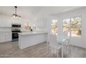 Bright, updated kitchen features stainless steel appliances, quartz countertops, and a cozy breakfast nook with backyard view at 8478 W Grovers Ave, Peoria, AZ 85382