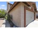 Close up side view of a two car garage with a stucco exterior and a side yard at 8876 W Bluefield Ave, Peoria, AZ 85382