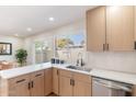 Well-lit kitchen featuring quartz countertops, stainless steel sink, and a large window overlooking the backyard at 1061 E Fremont Dr, Tempe, AZ 85282