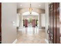 Spacious foyer featuring tiled floors, an elegant chandelier and large windows overlooking a backyard pool at 12120 E Cortez Dr, Scottsdale, AZ 85259