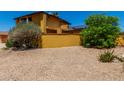 Backyard with xeriscape landscaping, trees and a yellow stucco wall for added privacy at 12459 N 36Th St, Phoenix, AZ 85032
