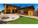 Backyard with an artificial lawn and a custom-built stone fire pit area, perfect for entertaining guests at 12459 N 36Th St, Phoenix, AZ 85032