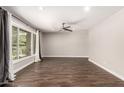 Spacious living room with wood-look flooring, neutral walls, ceiling fan, and a bright window at 1502 E Minton Dr, Tempe, AZ 85282